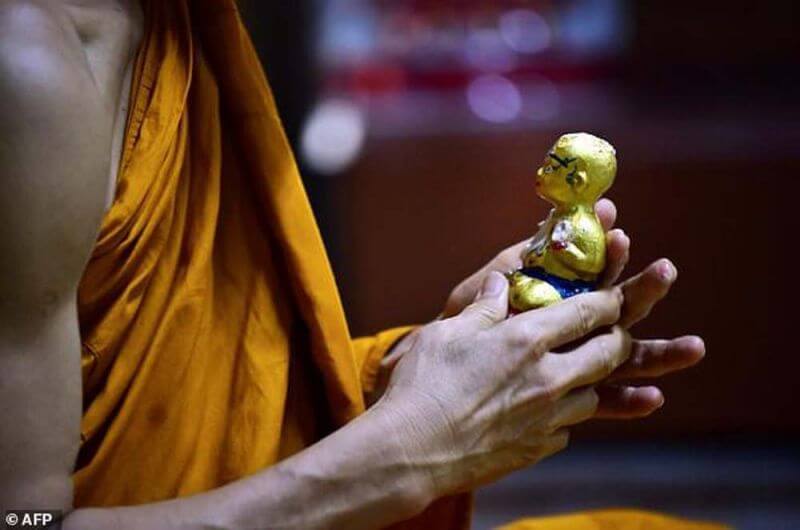 the monk hold small kuman thong