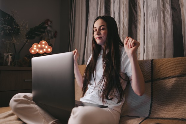 Woman sitting on a sofa with laptop at home